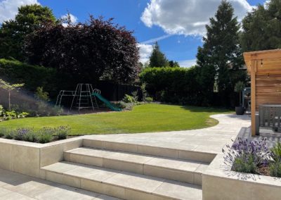 Flowing lawn shape adjacent to curved porcelain paving