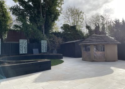 Porcelain paving, summer house, decorative screens and timber raised beds