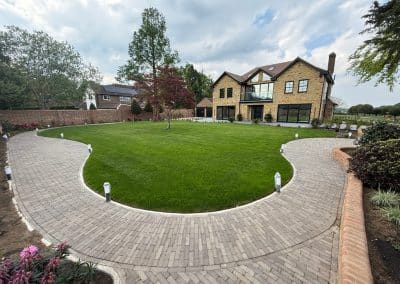 Curved clay paver path around the lawn